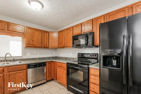A kitchen with wooden cabinets and black appliances.