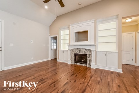 A spacious living room with a fireplace and built-in cabinets.
