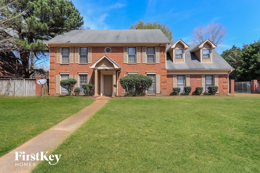 a large brick house with a lawn in front of it