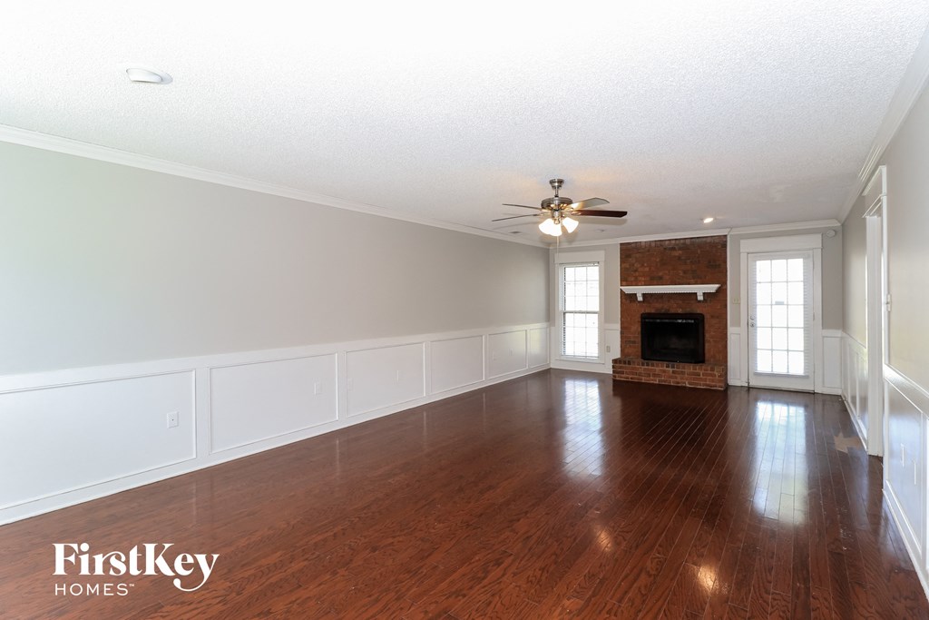 an empty living room with wood floors and a fireplace