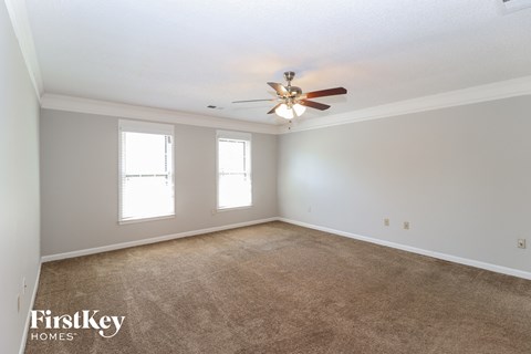 a living room with carpet and a ceiling fan