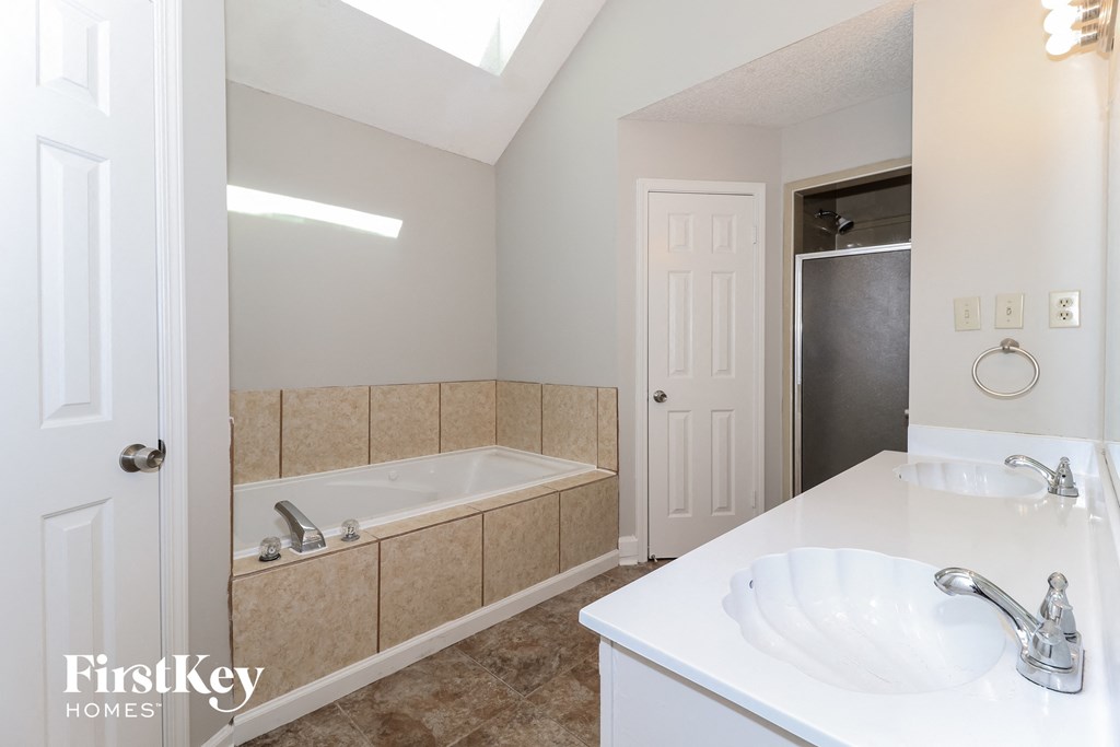 a bathroom with a tub and a sink and a mirror