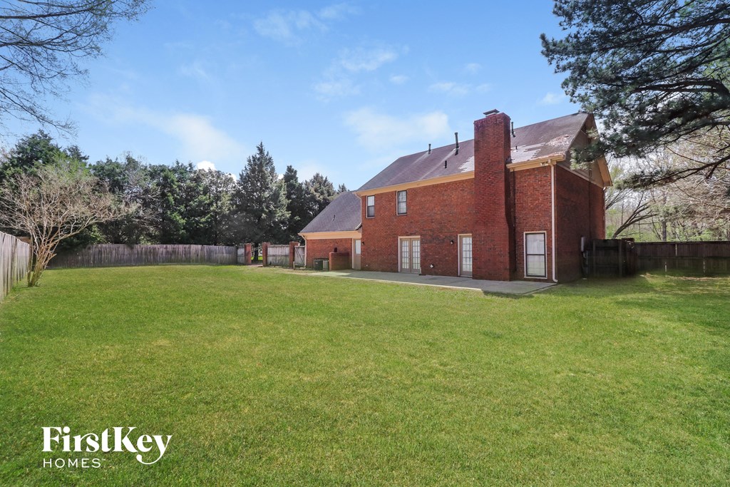 a large brick house with a yard in front of it