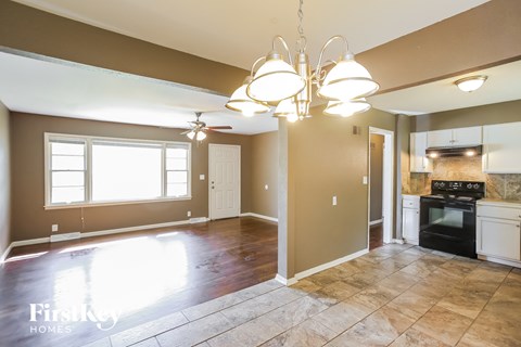 A kitchen area with a stove and oven, and a dining area with a table and chairs.