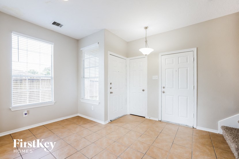 an empty living room with two closets and a tiled floor