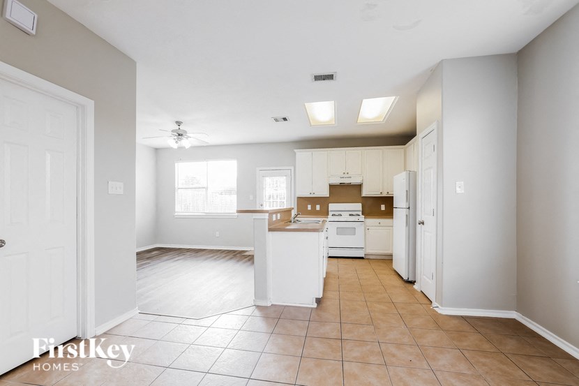 an empty kitchen with white cabinets and white appliances