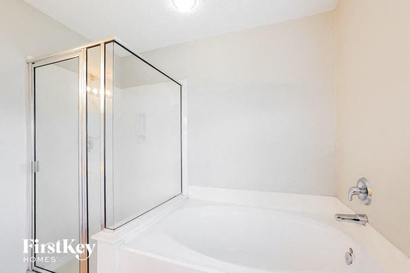 a white bathroom with a shower and a sink