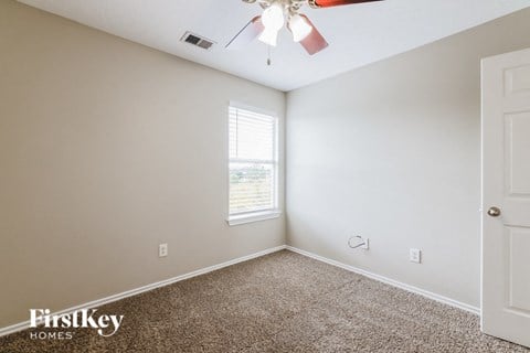a bedroom with a carpeted floor and a ceiling fan