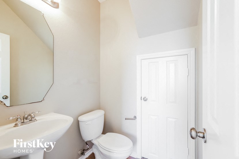 a bathroom with a toilet and a sink and a mirror