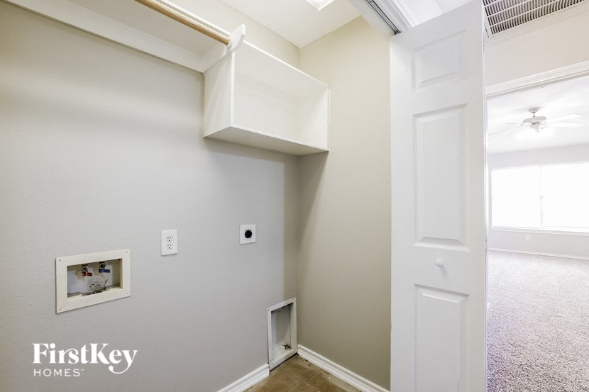 a hallway with a white door and a white wall with a window and a staircase