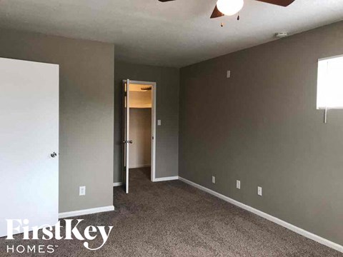 a bedroom with gray walls and a door to a closet