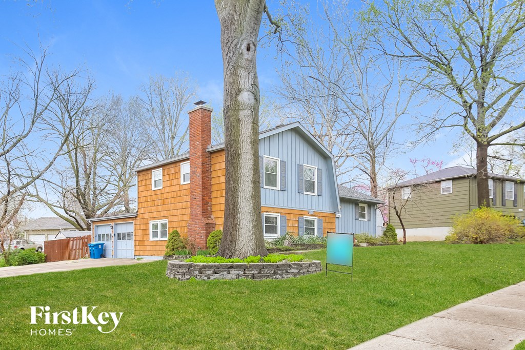 a blue house with a large tree in front of it