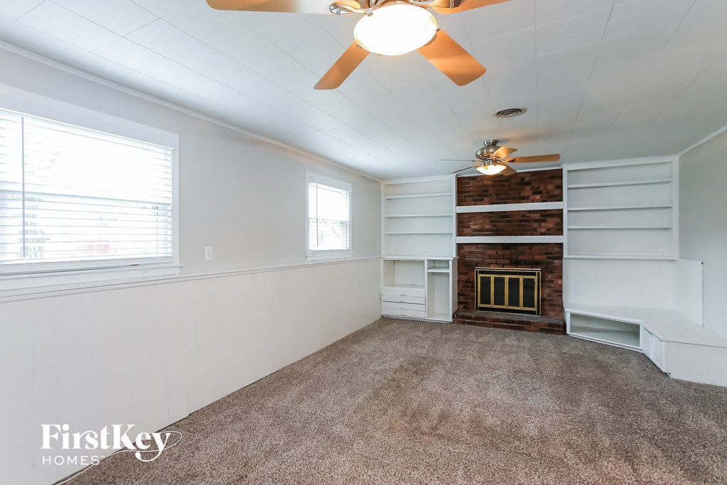 a living room with a fireplace and a ceiling fan