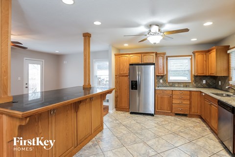 a kitchen with wooden cabinets and a stainless steel refrigerator