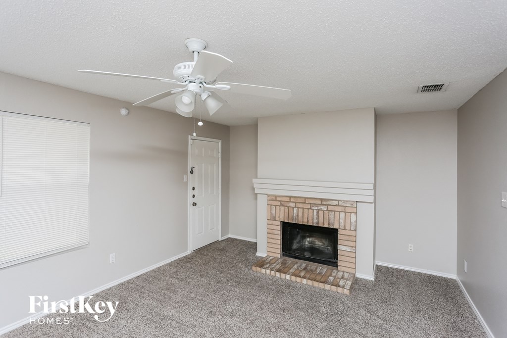 a living room with a fireplace and a ceiling fan