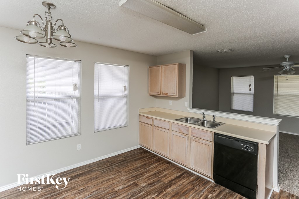 a kitchen with wood flooring and a sink and counter top