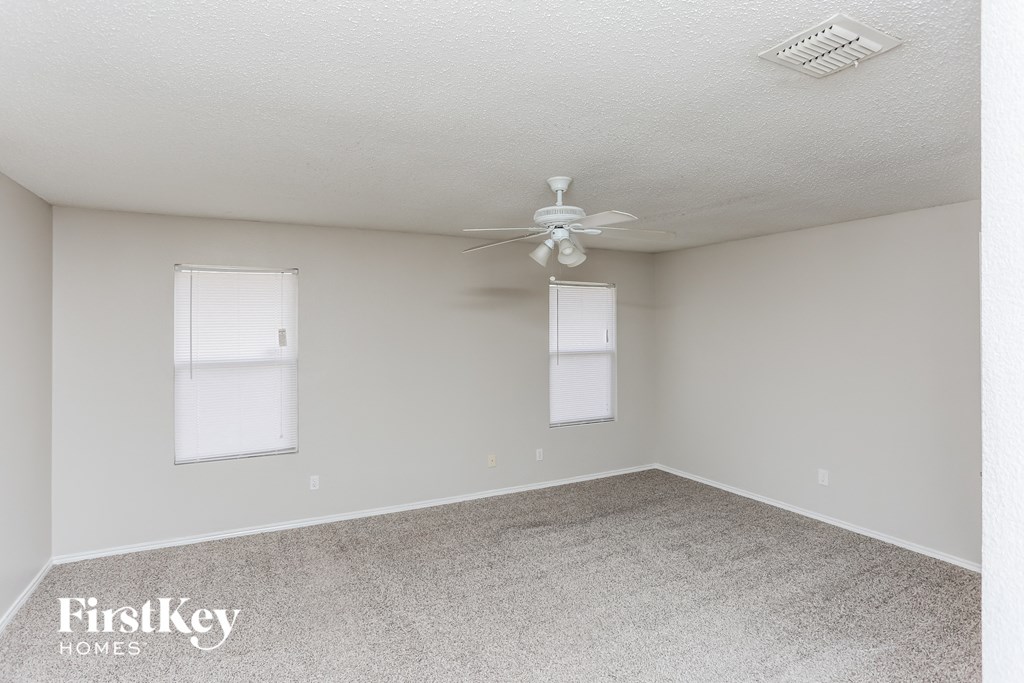 a room with carpet and a ceiling fan