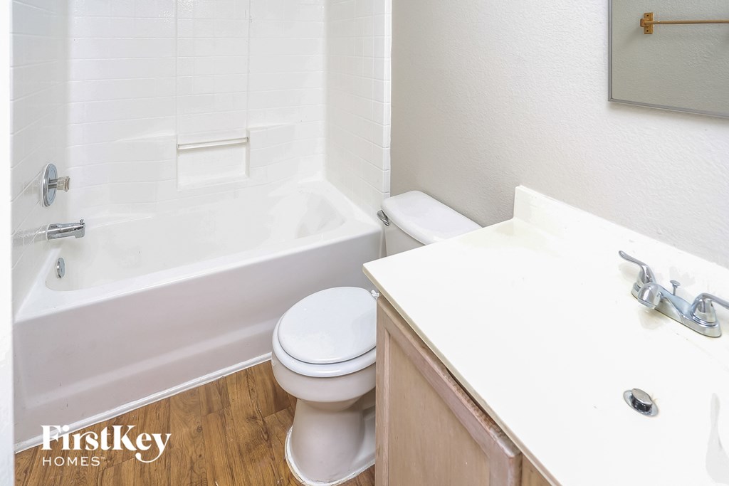 a bathroom with a toilet and a tub and a sink