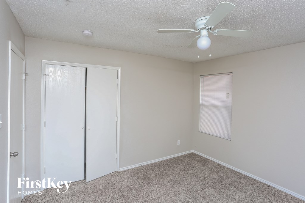 a bedroom with a ceiling fan and a closet