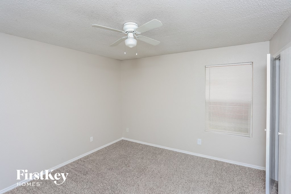 a empty room with a ceiling fan and a window