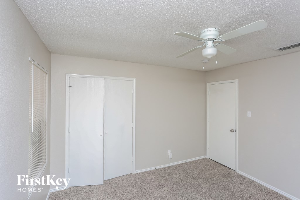 a bedroom with a ceiling fan and a closet