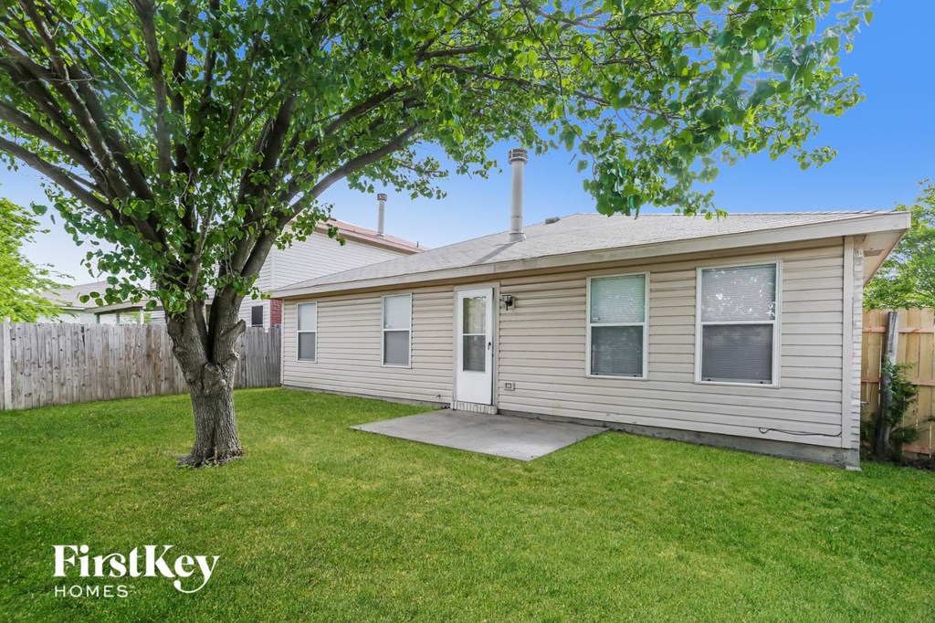 a white house with a yard and a tree