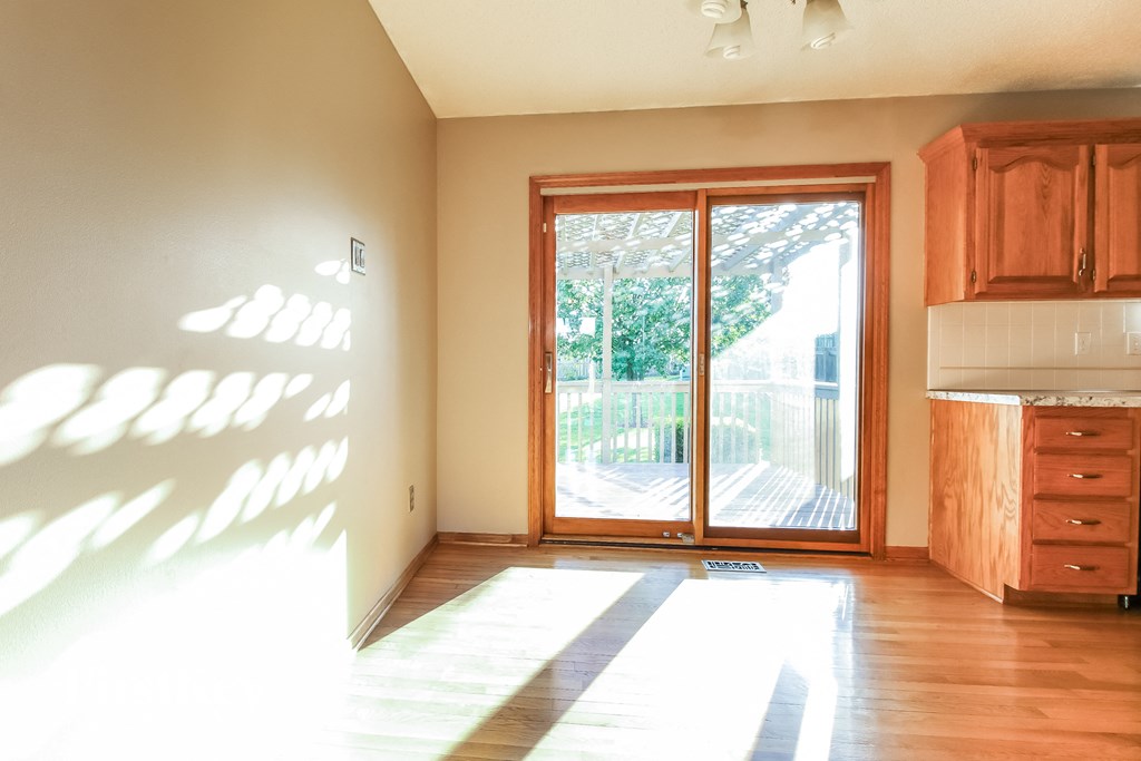 A sunny room with a wooden floor and a large window.