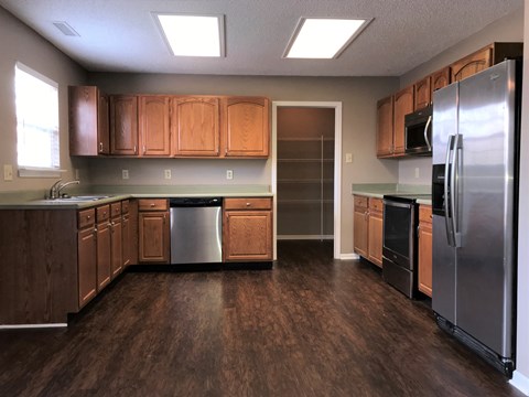 A kitchen with wooden cabinets and a refrigerator.