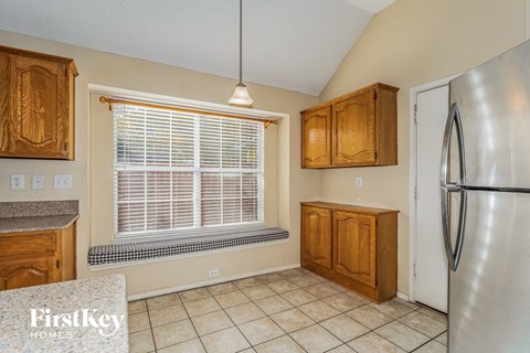 A kitchen with wooden cabinets and a tiled floor.