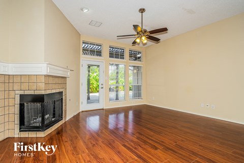A spacious room with a fireplace and sliding glass doors.