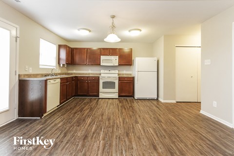A kitchen with wooden floors and brown cabinets.