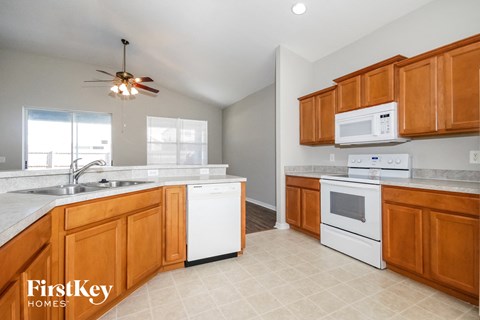 a kitchen with wooden cabinets and white appliances and a sink
