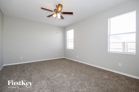 a bedroom with carpet and a ceiling fan