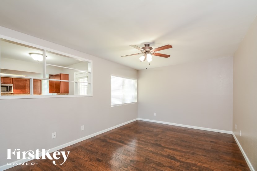 A room with a ceiling fan and wooden flooring.
