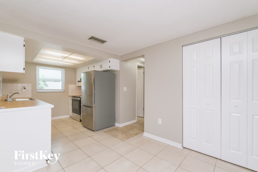 A kitchen with white cabinets and a refrigerator.