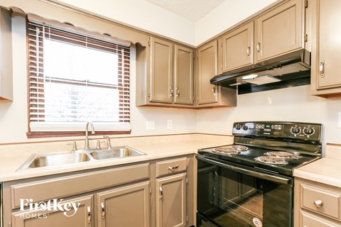 a kitchen with a sink and a stove and a window