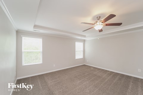 a living room with a ceiling fan and a carpet