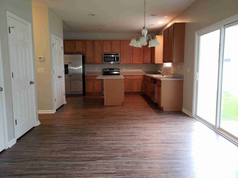 A kitchen with wooden cabinets and a refrigerator.