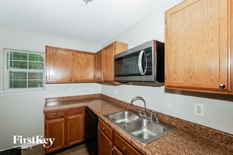 A kitchen with wooden cabinets and a granite countertop.