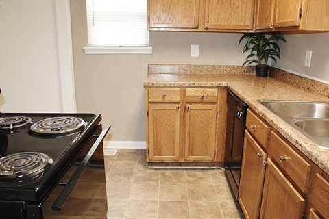 A kitchen with wooden cabinets and a black stove top.