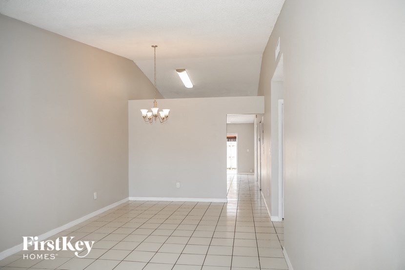 A large empty room with a chandelier and a light on the ceiling.