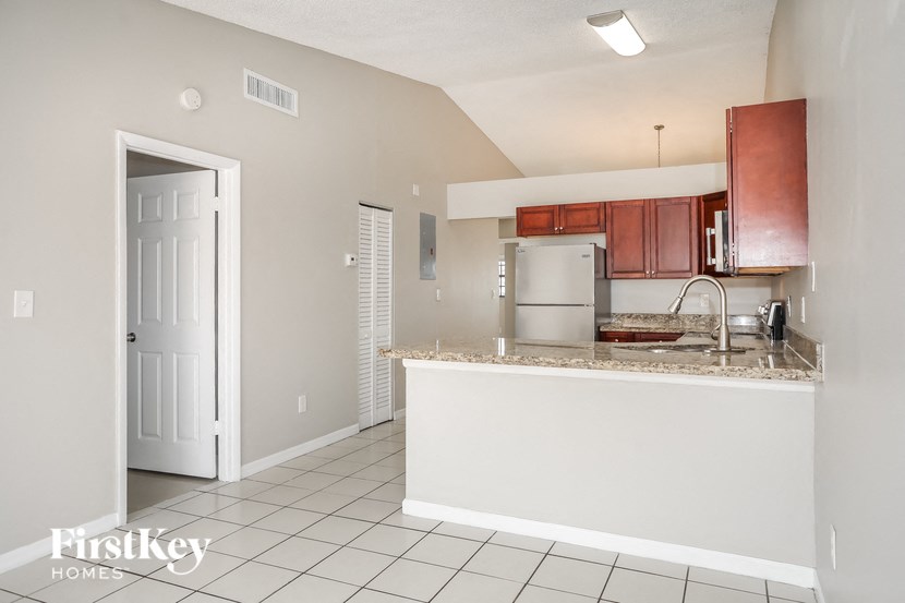 A kitchen with white cabinets and a white door.
