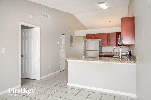 A kitchen with white cabinets and a white door.