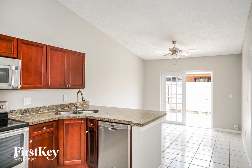 A kitchen with brown cabinets and a white ceiling.