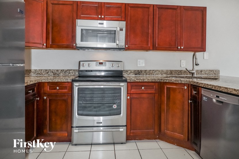 A kitchen with wooden cabinets and a stainless steel oven.