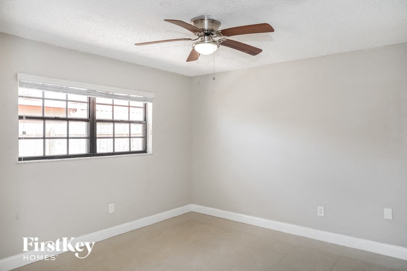 A room with a ceiling fan and a window.