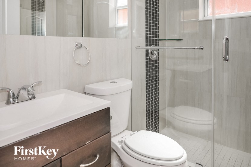 A white toilet sits next to a sink in a bathroom.