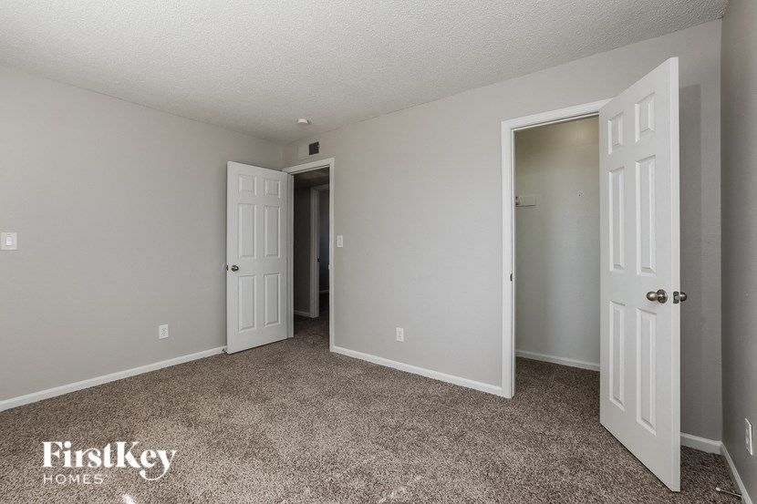 a bedroom with two doors and a carpeted floor