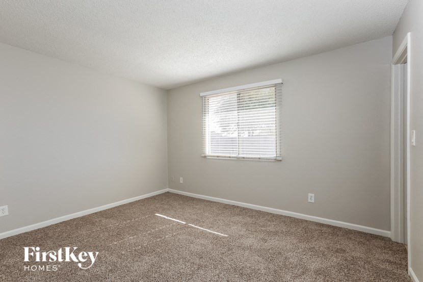 a bedroom with a carpeted floor and a window