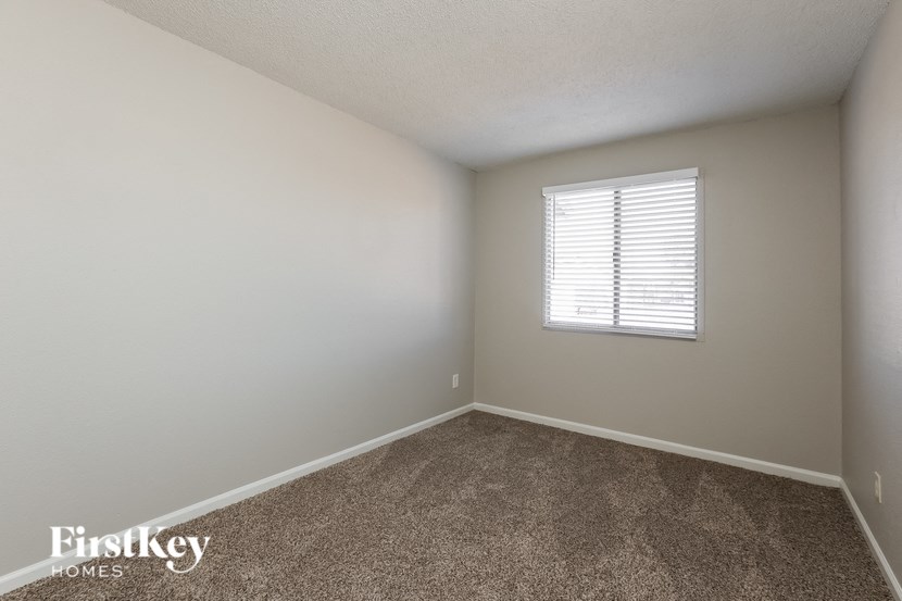 an empty room with carpet and a window